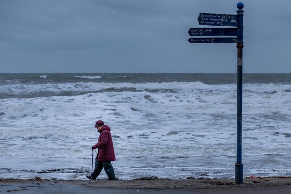©Neil Turner, November 2014. A pensioner walks along the beach near Bournemouth Pier.