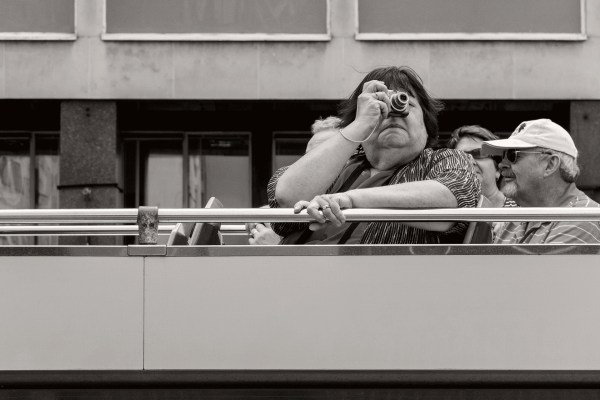 Passenger on the top deck of a tourist bus passing through Waterloo. © Neil Turner
